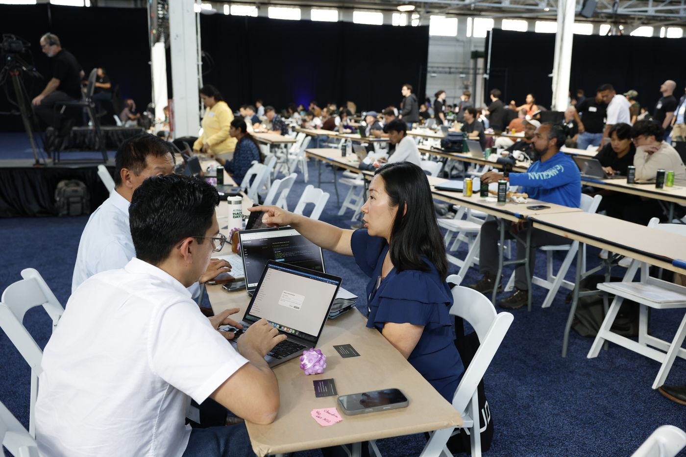 Teams working at long tables during the Hack Day at The AI Conference 2026